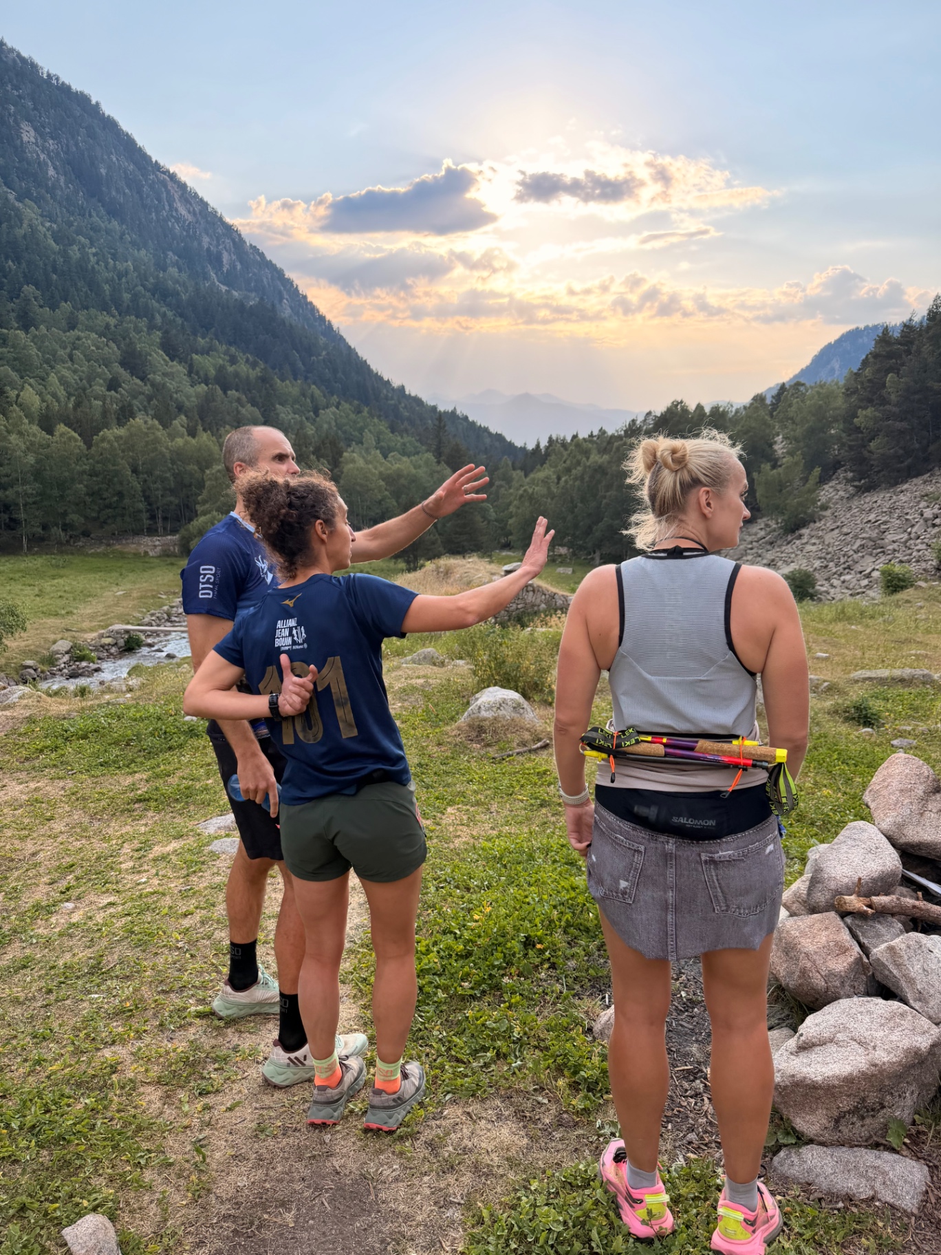 Founders and explorers discussing routes together in a Pyrenees valley at golden hour